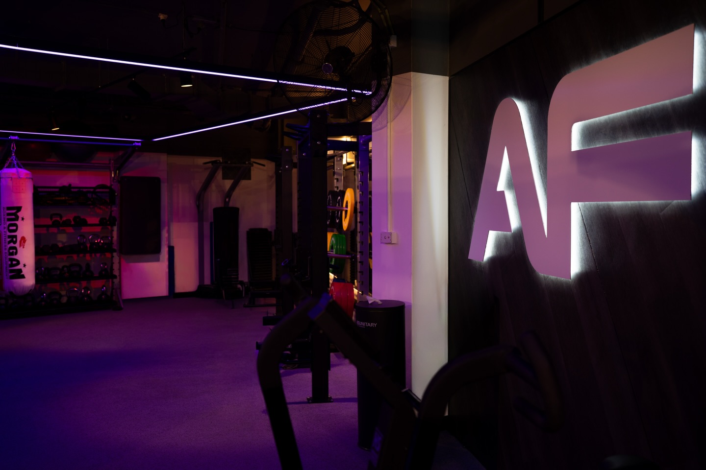 Illuminated gym signage and boxing equipment in low light