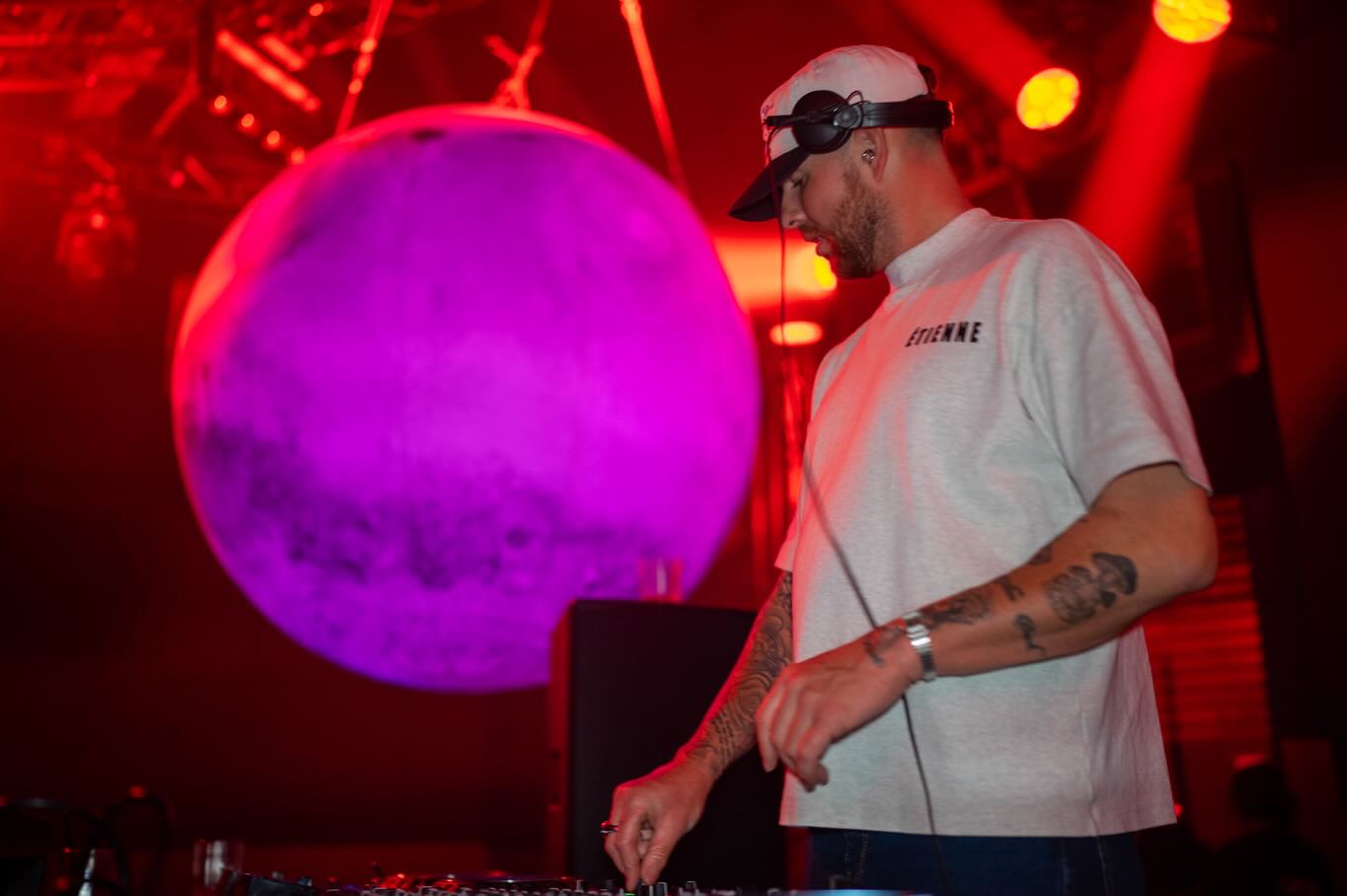 DJ performing under a glowing purple light at a Sydney event