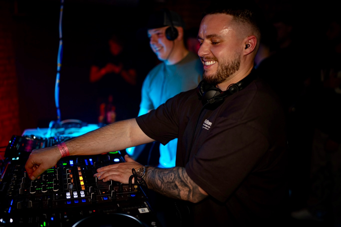 DJ smiling behind the decks at a club night