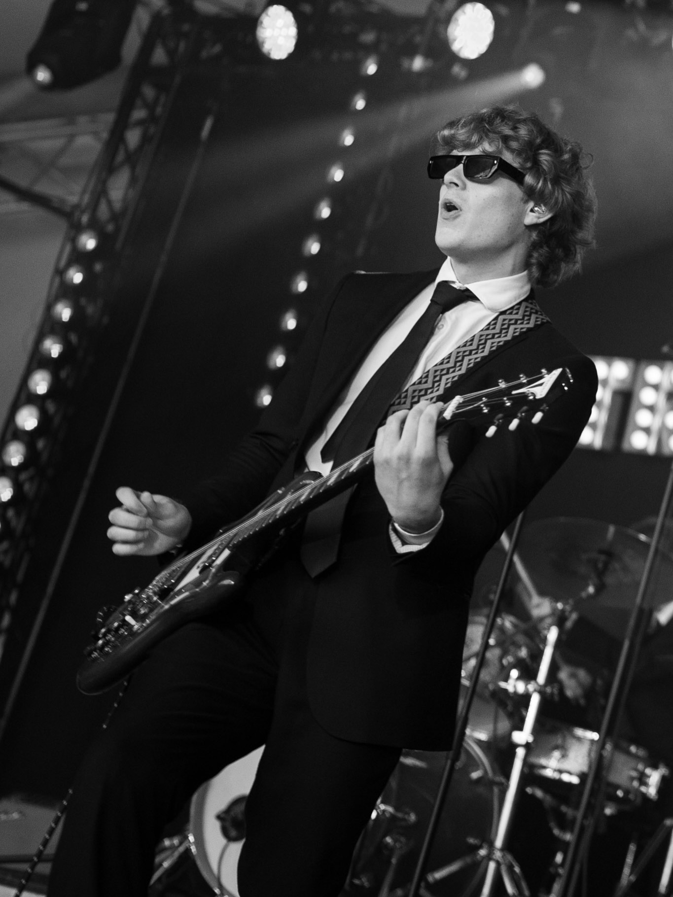 Guitarist on stage in black and white under bright stage lights